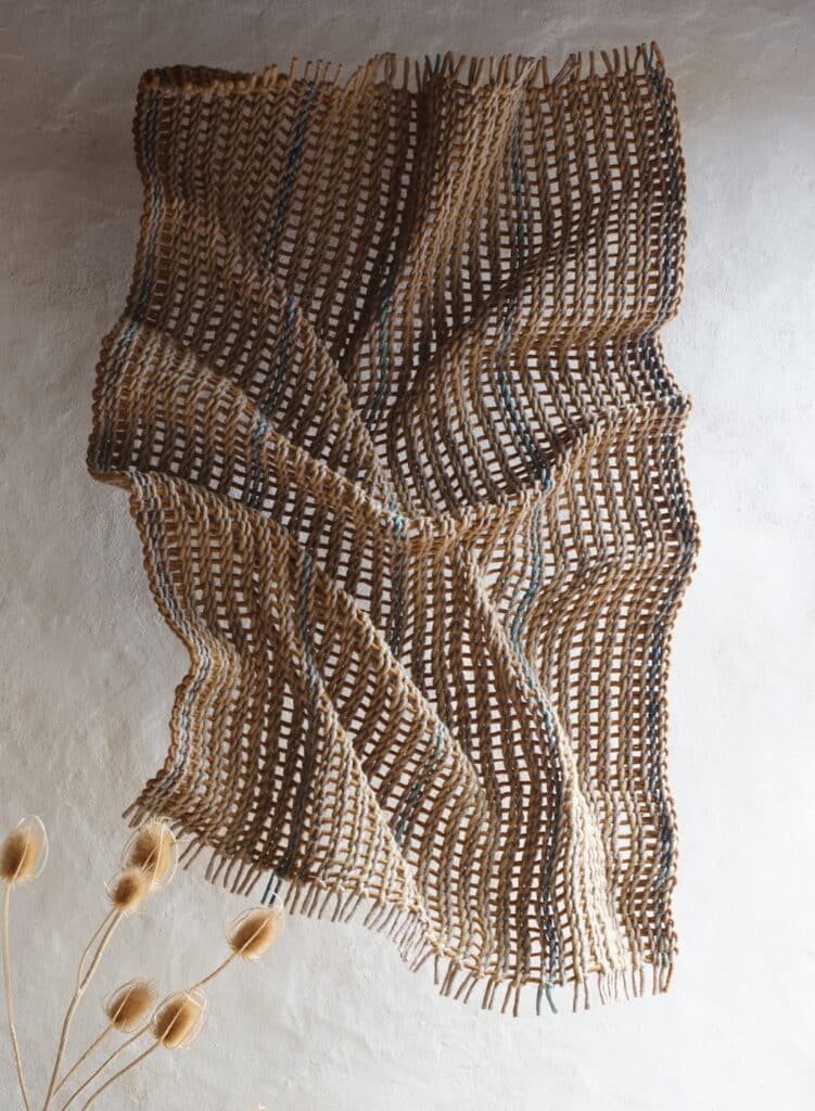 Drapé constitué de tiges de feutre de laine tressées, ocre jaune, beige